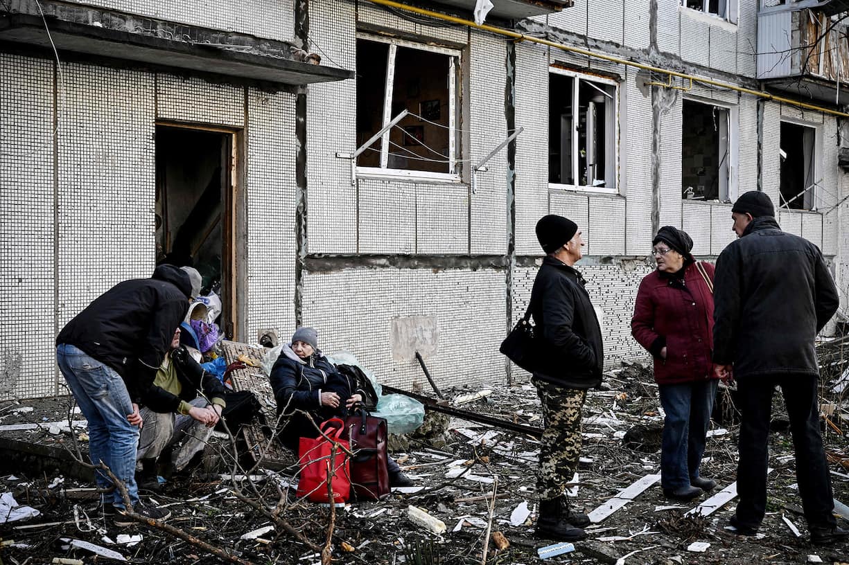 Des habitants devant leur immeuble atteint par un bombardement.
