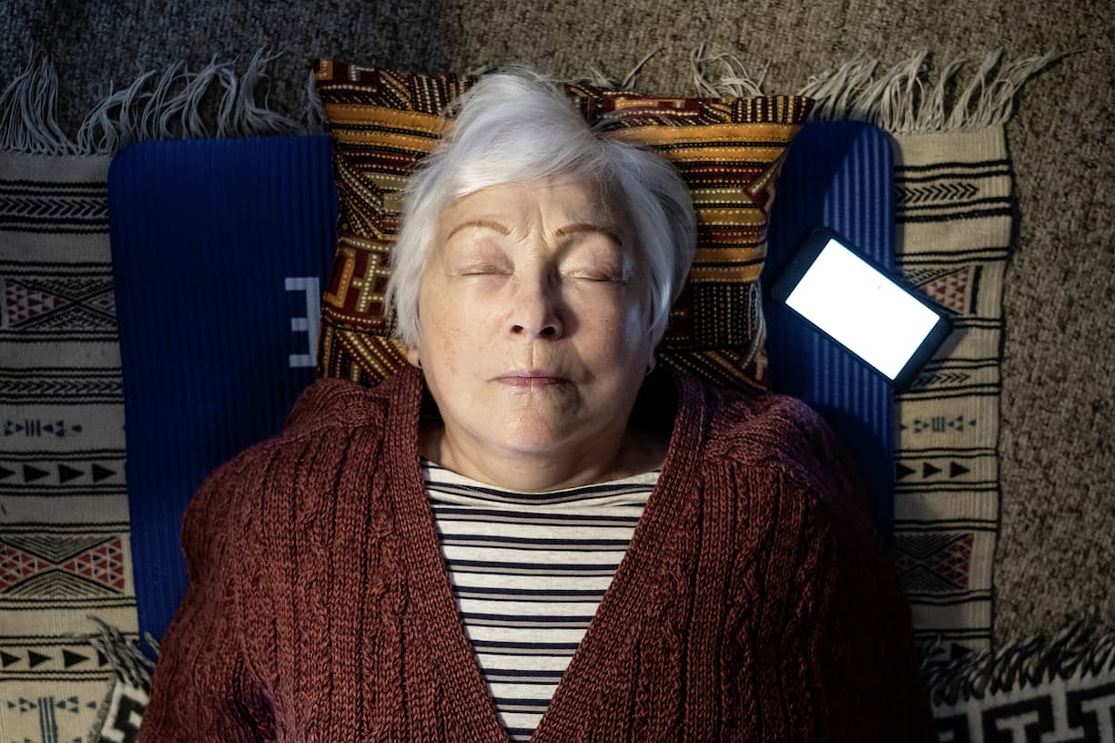 Françoise Golay médite sur le sol dans son appartement d'Yverdon