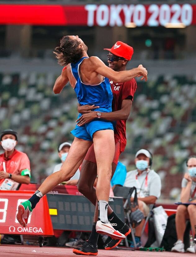 epa09385577 Gold Medalists Gianmarco Tamberi of Italy (L) and Essa Mutaz Barshim of Qatar (R) react after the Men's High Jump Final during the Athletics events of the Tokyo 2020 Olympic Games at the Olympic Stadium in Tokyo, Japan, 01 August 2021. EPA/DIEGO AZUBEL