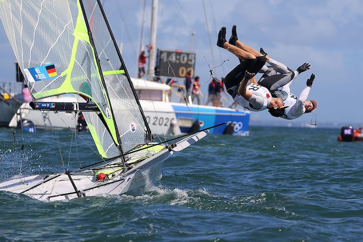 Tokyo 2020 Olympics - Sailing - Men's 49er - Medal Race - Enoshima Yacht Harbour - Tokyo, Japan - August 3, 2021. Erik Heil of Germany and Thomas Ploessel of Germany jump into the water as they celebrate winning bronze after the race. REUTERS/Carlos Barria SEARCH "OLYMPICS DAY 12" FOR TOKYO 2020 OLYMPICS EDITOR'S CHOICE, SEARCH "REUTERS OLYMPICS TOPIX" FOR ALL EDITOR'S CHOICE PICTURES.TPX IMAGES OF THE DAY.